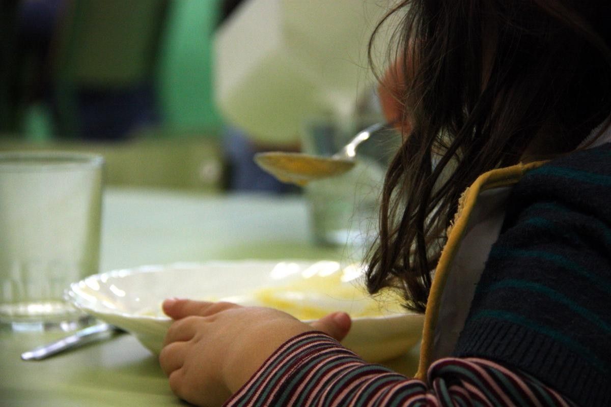 Una nena en un menjador escolar.