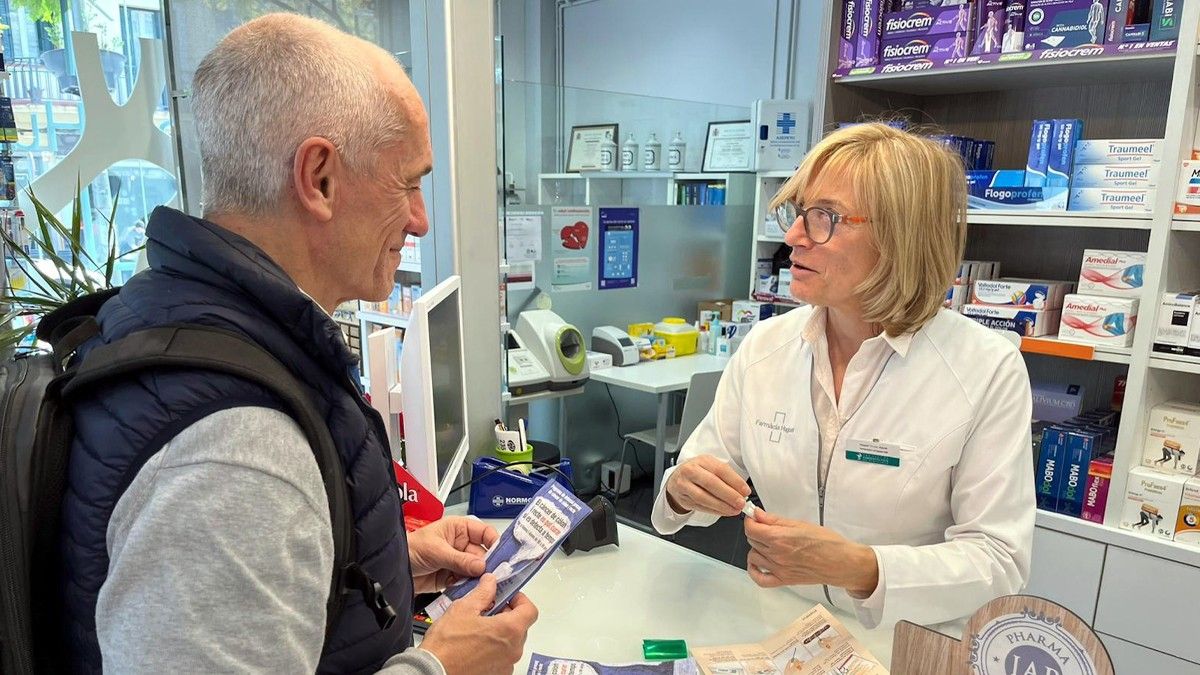 Un home recollint el kit per al cribatge del càncer de còlon en una farmàcia