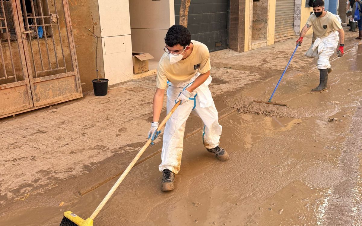 Iván López en primer terme fent tasques de neteja en un dels pobles de l'Horta Sud afectats per la dana.