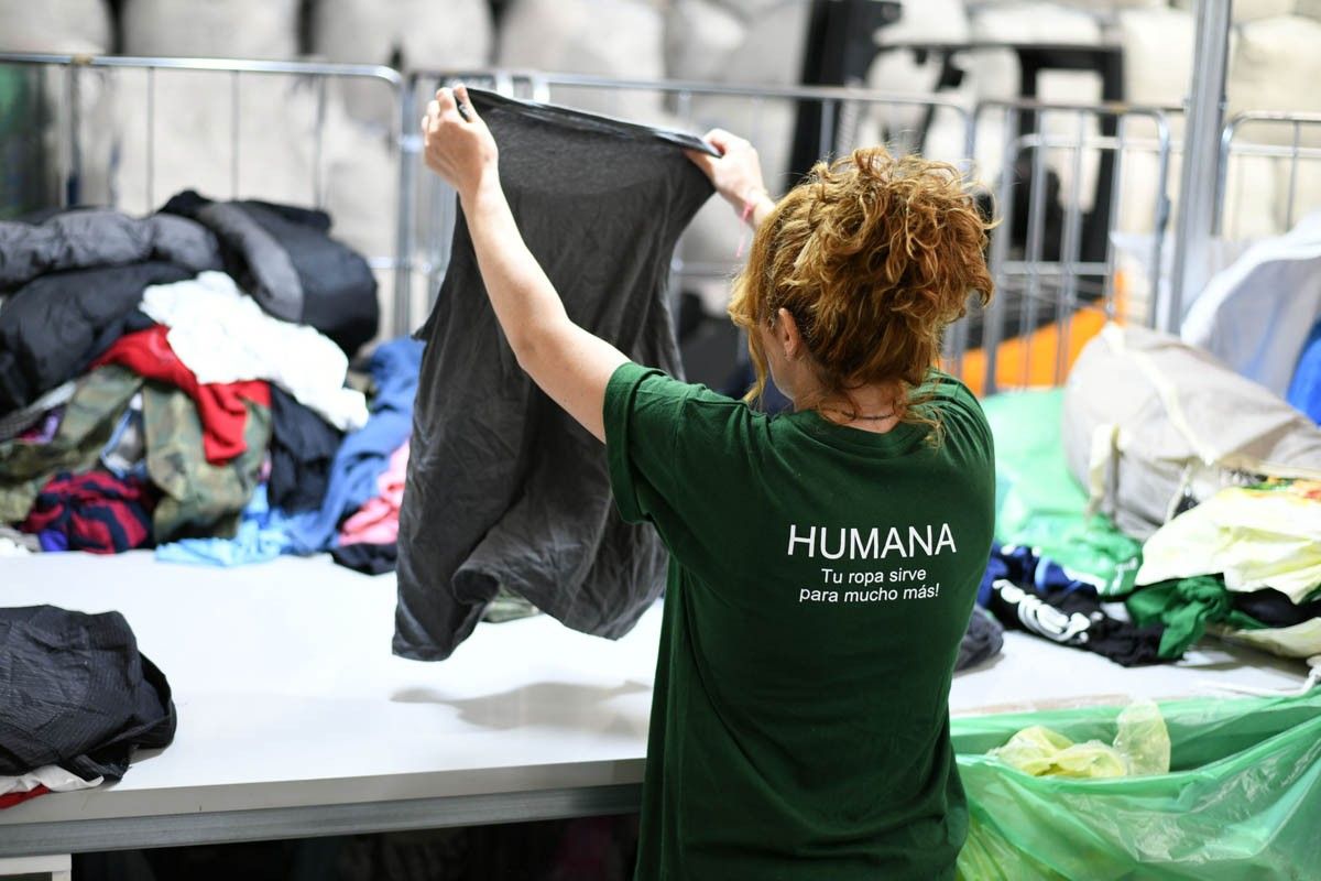 Una col·laboradora d'Humana classificant peces de roba usades
