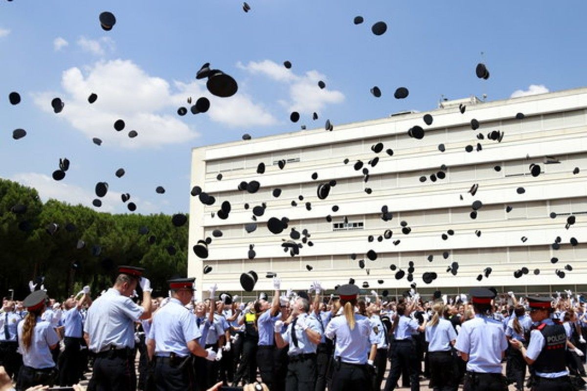Els nous policies trenquen files i llancen les gorres a l'aire per celebrar la seva graduació.
