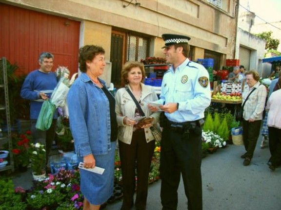 Un agent de policia parlant amb dues ciutadanes al mercat de Sant Celoni