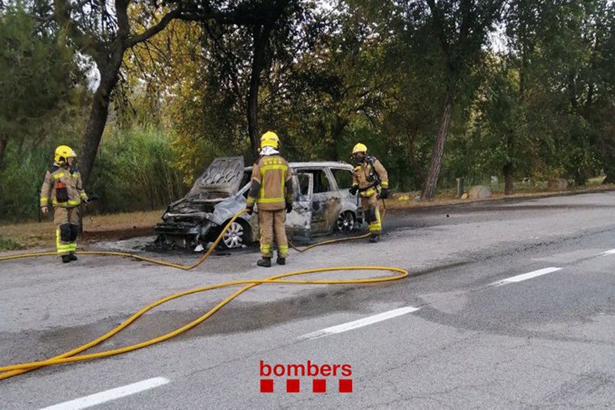 Una dotació de bombers apagant el foc del vehicle incendiat a l'AP-7 a Sant Celoni