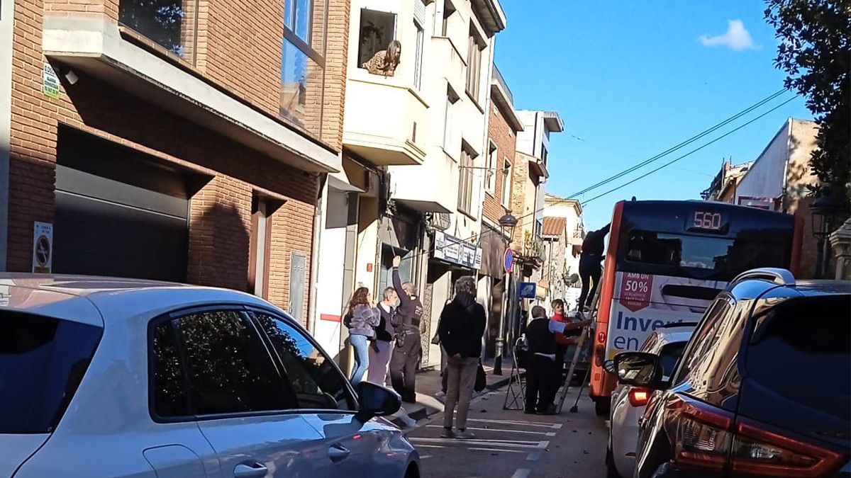 Un policia local de Sant Celoni aguanta el cable de telèfon que ha provocat retencions a la Carretera Vella.