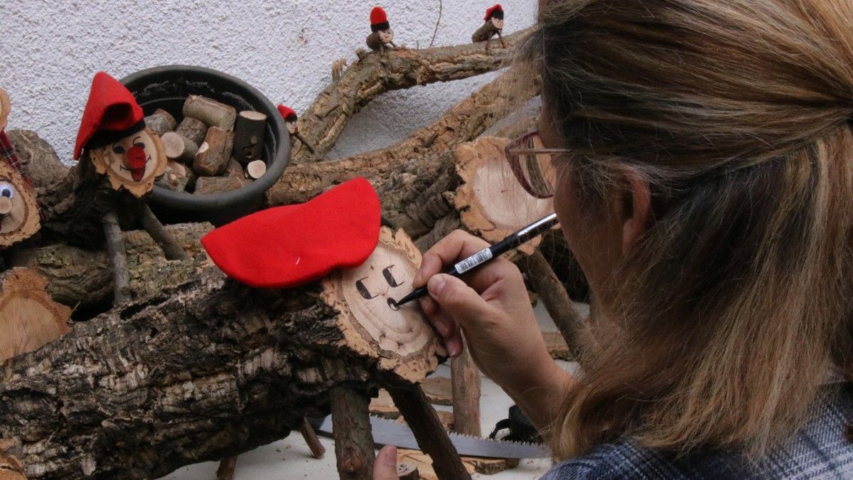 Pintant la cara d'un dels tions fets amb troncs dels boscos d'Arbúcies.