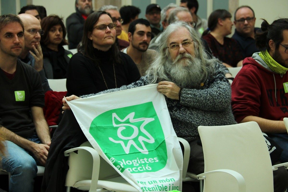 Un activista mostra una pancarta d'Ecologistes en Acció, a l'Auditori del Parlament