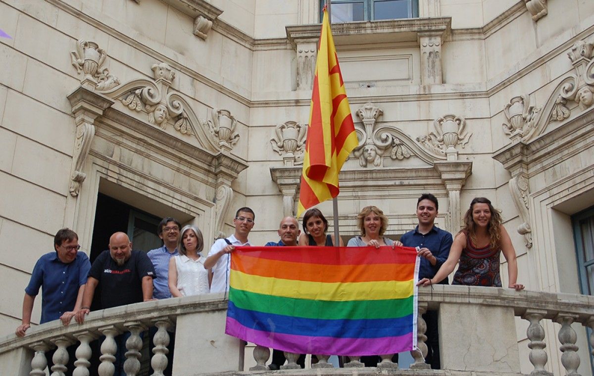 Membres de l'associació Talcomsom i regidors de l'Ajuntament de Berga penjant la bandera irisada.