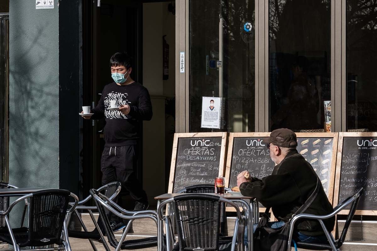 Un cambrer serveix cafè amb mascareta a Barcelona.