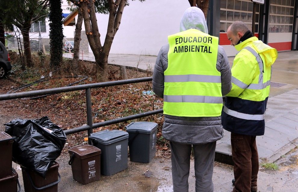 Un educador ambiental revisant els cubells del servei de recollida selectiva en un municipi de Catalunya.