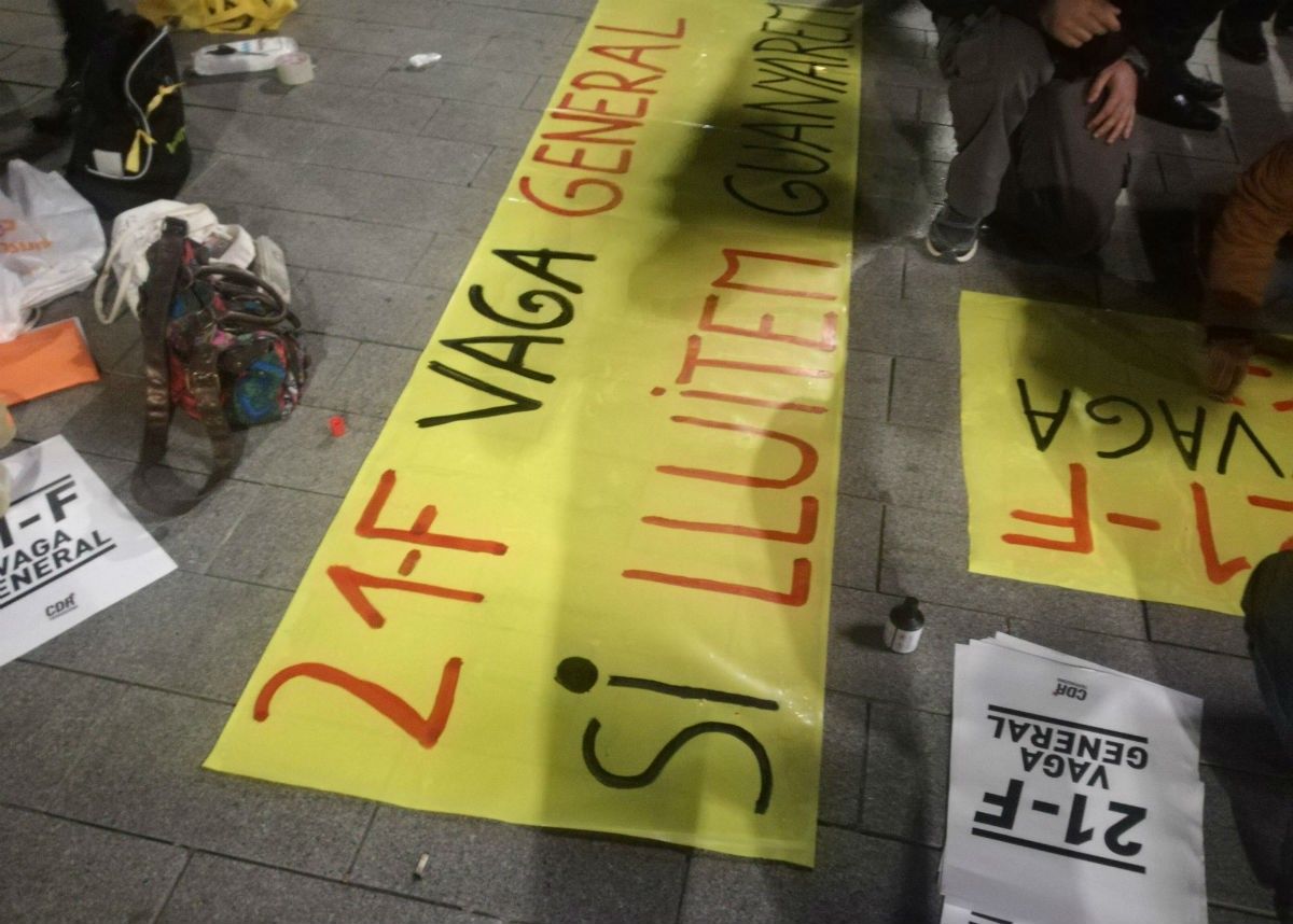 Diverses persones preparant pancartes per al 21-F en una població catalana. 