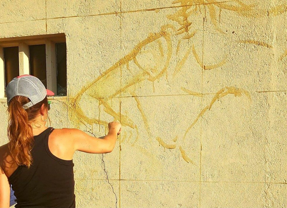 Elena Boix, pintant el mural a Olvan