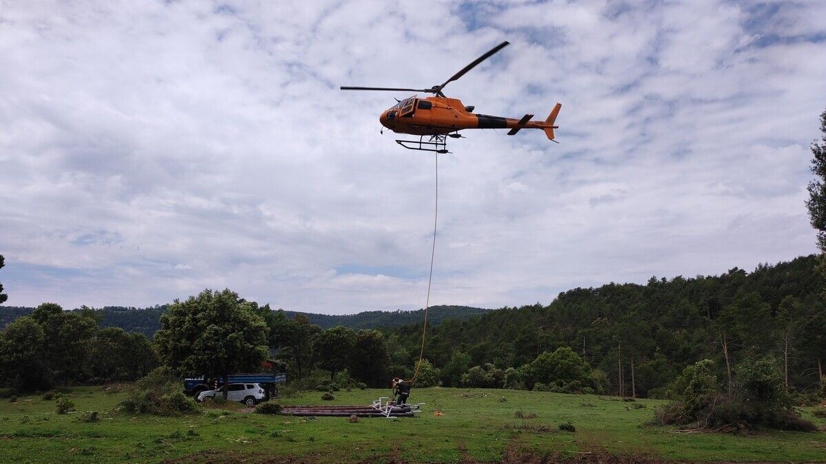 L'helicopter, treballant en la instal·lació dels nous suports del cablejat elèctric