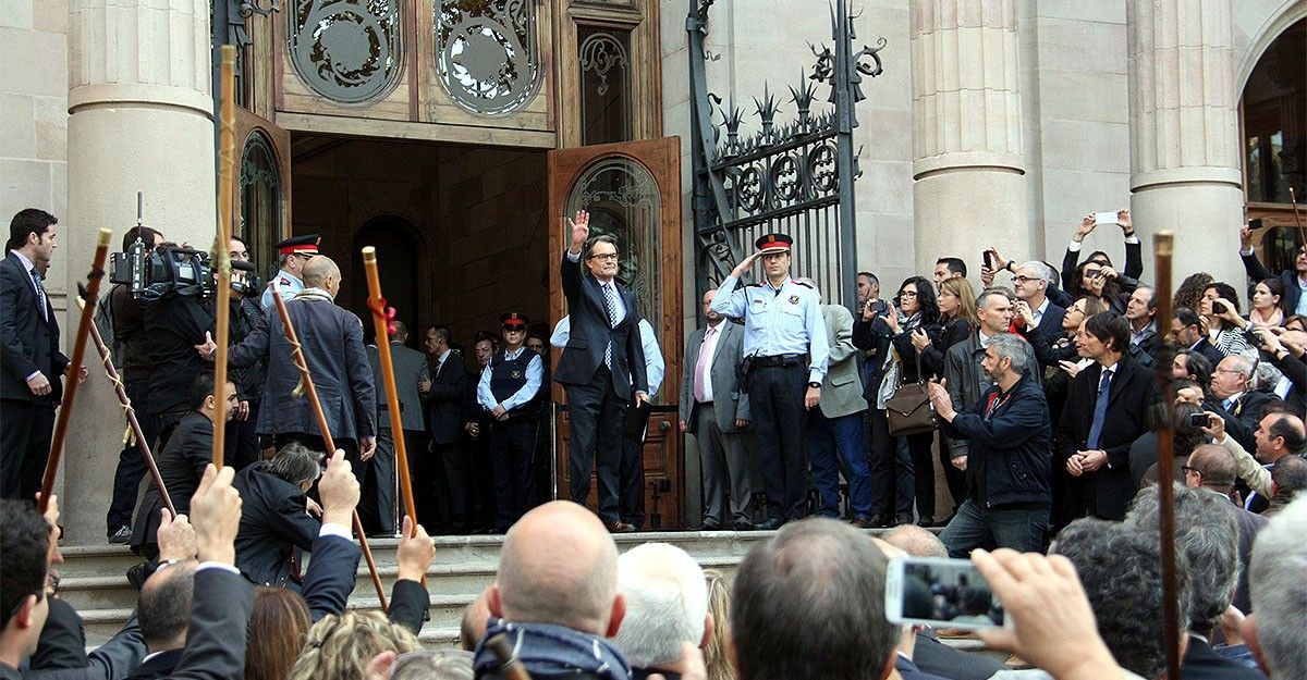 Artur Mas saludant, mentre els alcaldes alcen les vares.