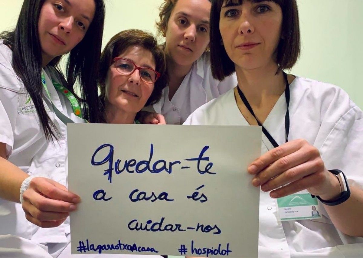 Treballadores de l'Hospital d'Olot mostren l'etiqueta de la campanya.