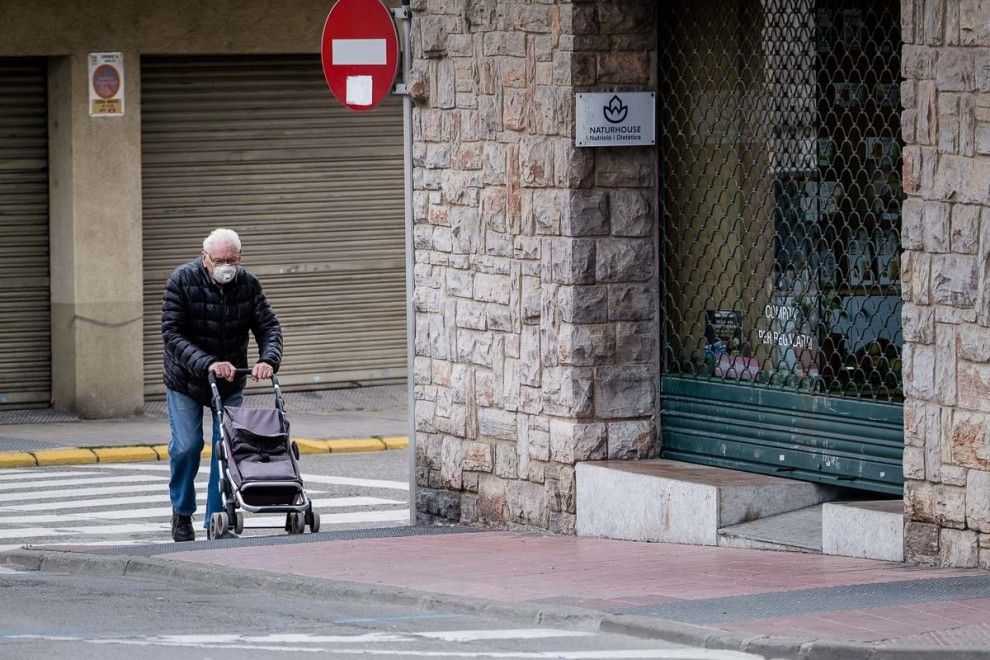 Un home gran caminant pel carrer amb una mascareta