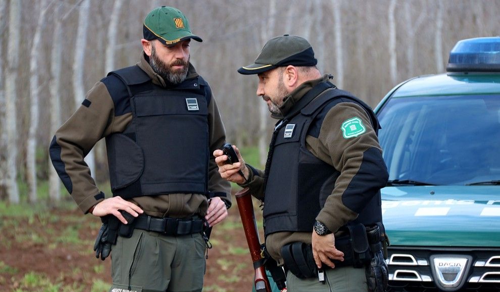 Imatge de dos agents amb armes i armilles.