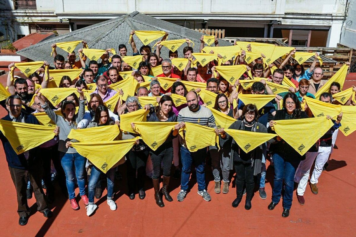 Castellers i membres d'Òmnium mostrant el mocador groc.