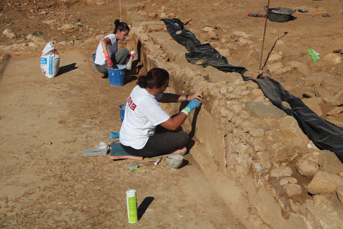 Dues restauradores treballen al jaciment de Can Ring de Besalú, en una foto d'arxiu