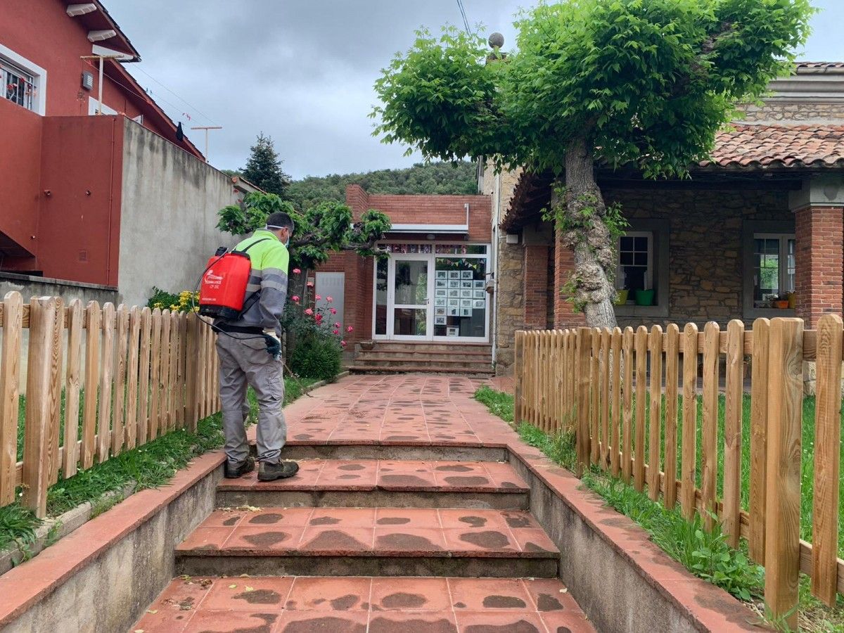 Un treballador municipal desinfecta els voltants de la llar d'infants a Sant Esteve d'en Bas.