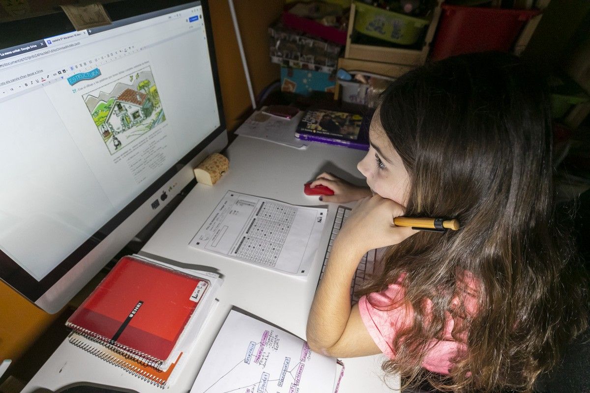Una noia fent els deures, durant el confinament.