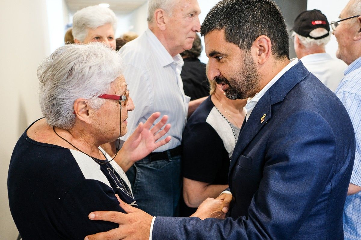 El conseller Chakir el Homrani parla amb una usuària del nou centre per a la gent gran durant la inauguració del Mirador del Puigsacalm.