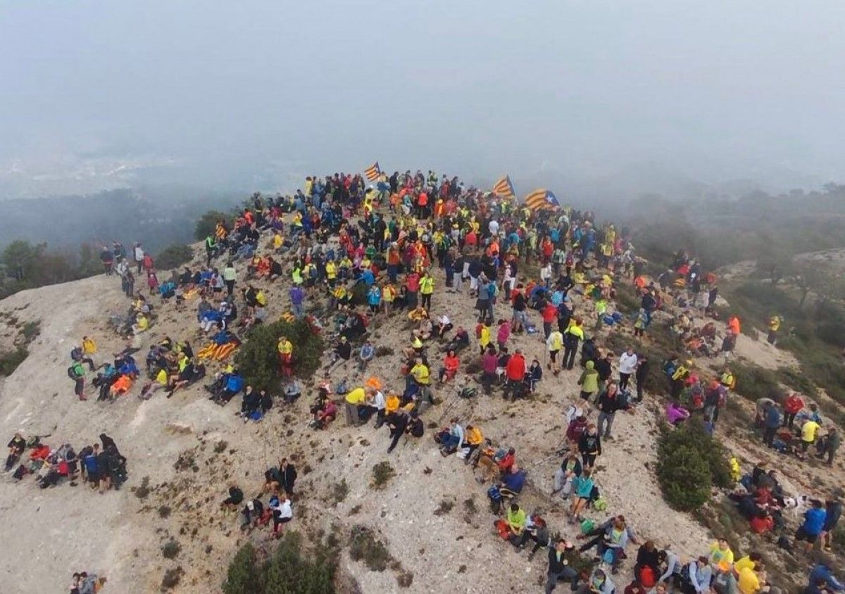 Desenes de persones amb banderes estelades al cim de la Roca Corbatera