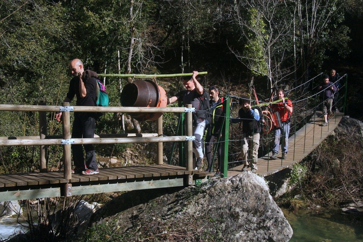 Un grup de voluntaris ben carregats de materials per al refugi de Sant Aniol d'Aguja.