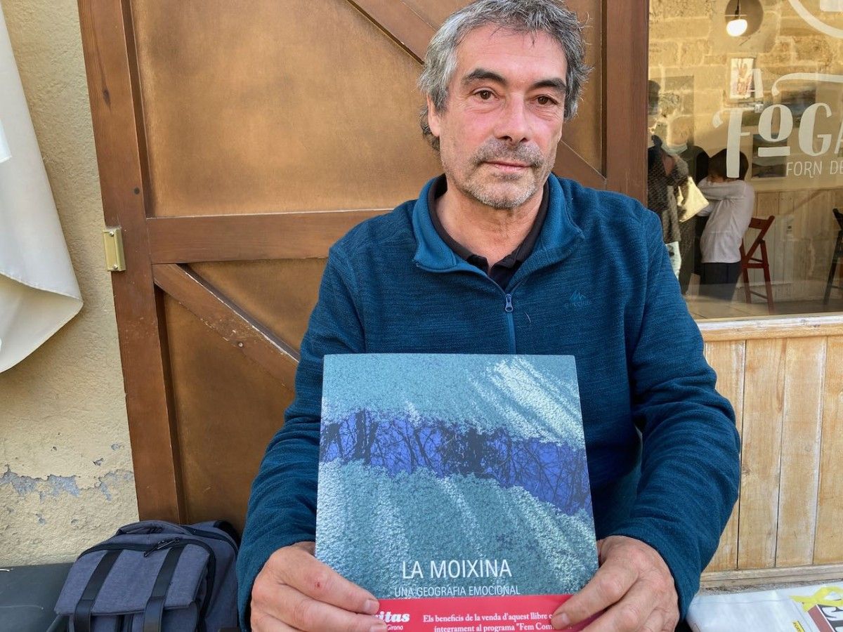 Miquel Macias, durant l'entrevista, amb el llibre sobre la Moixina que acaba de publicar.