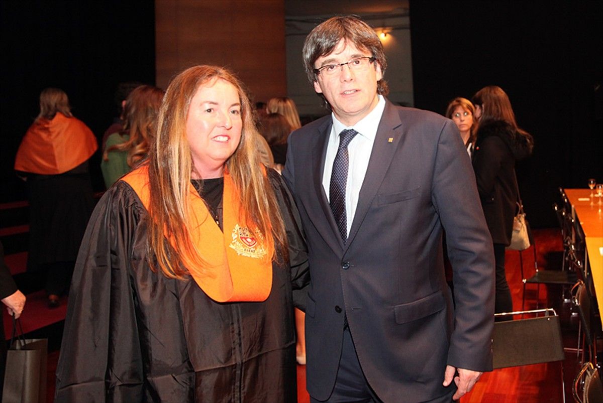 Pilar Curós recollint la Medalla al Mèrit Professional d'ESERP al costat del president Puigdemont