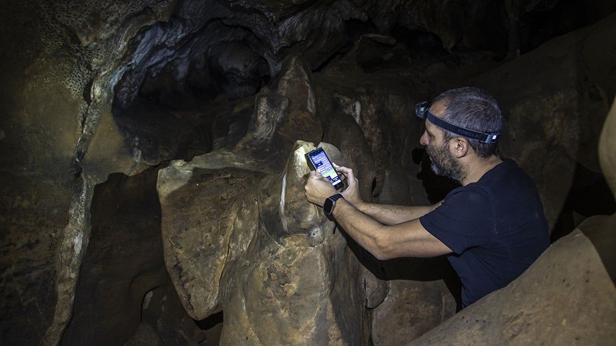 Un investigador descarregant dades del sensor de temperatura  la cova dels Muricecs de Limiana