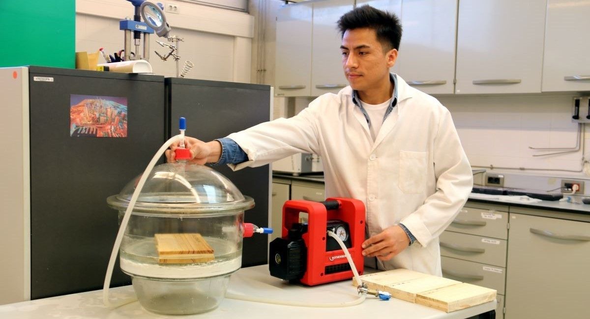Un estudiant doctoral utilitza una màquina d'impregnació al buit