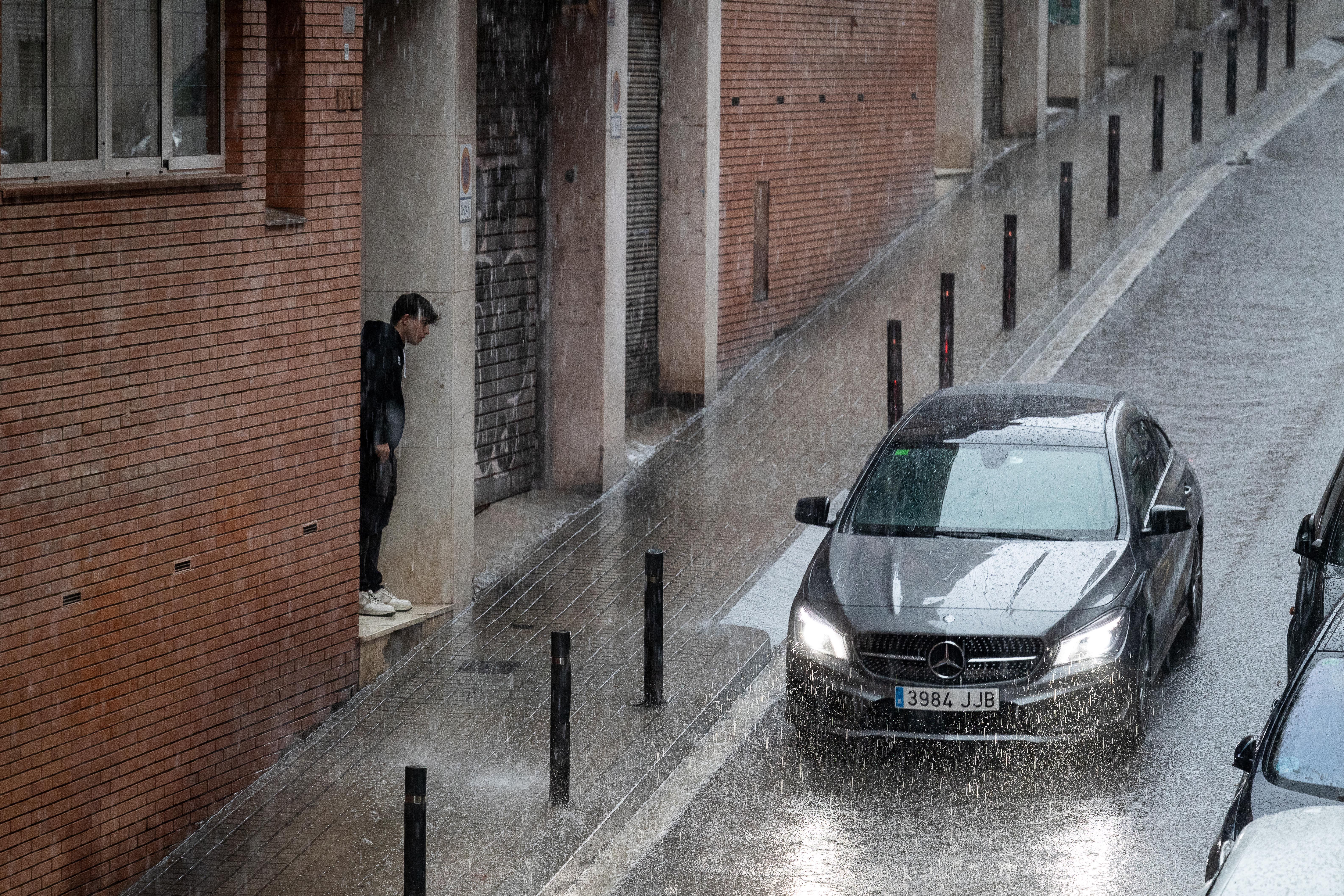 Un vehicle circula per Barcelona en un dia plujós