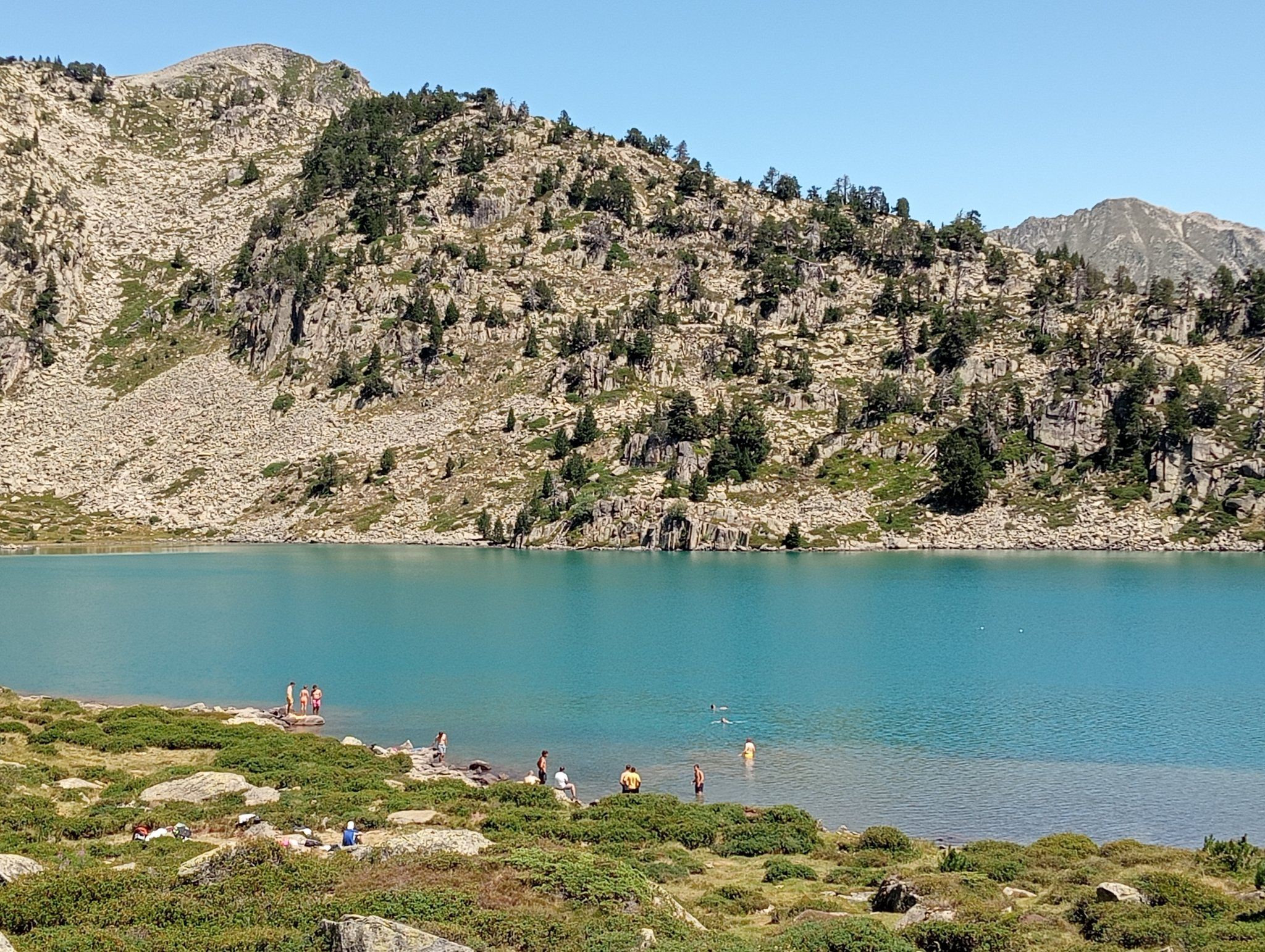 Una quinzena de persones banyant-se fa pocs dies a l'estany de la Gabarrea, al parc natural de l'Alt Pirineu