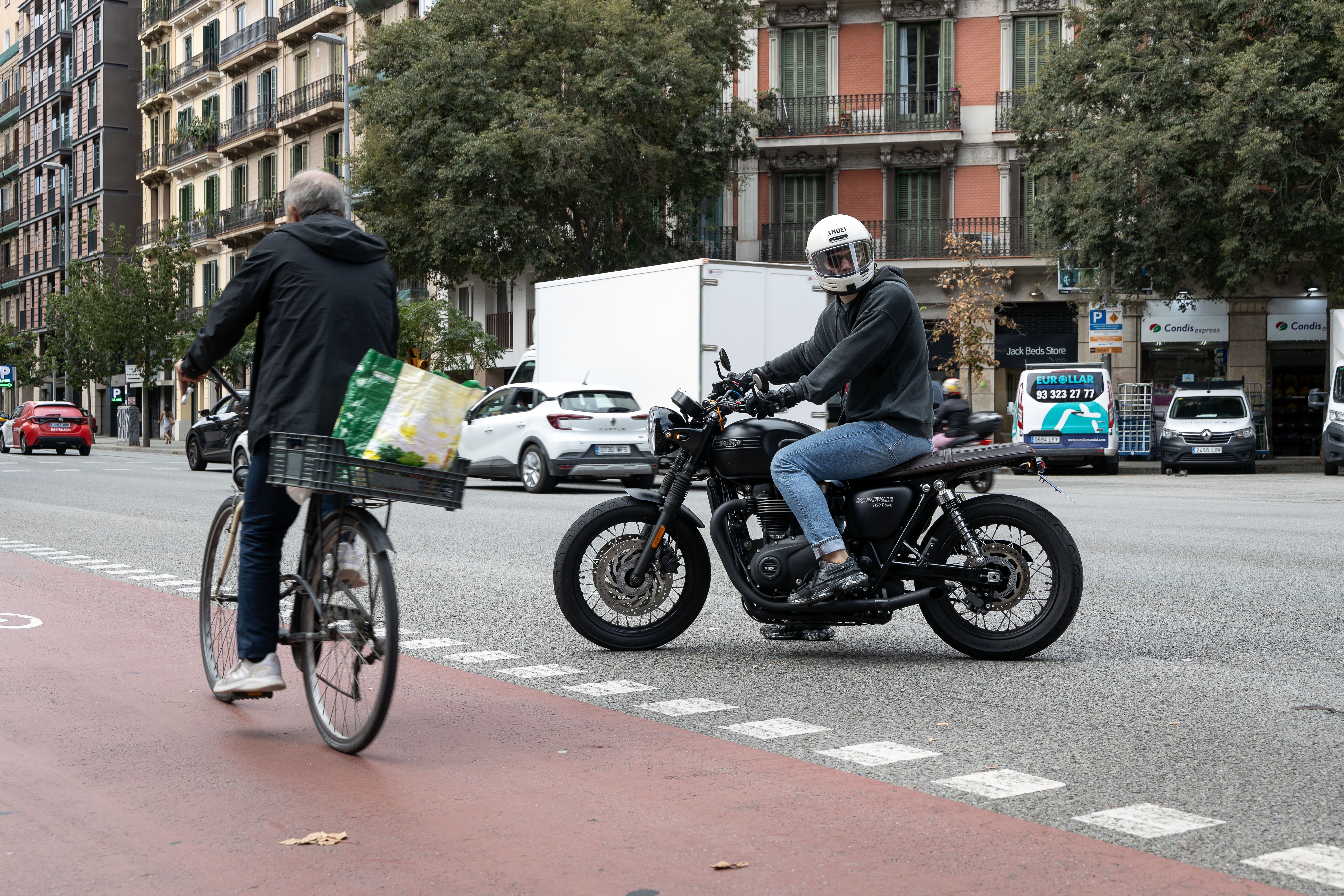 Un ciclista al carrer Aragó de Barcelona, amb una moto a tocar