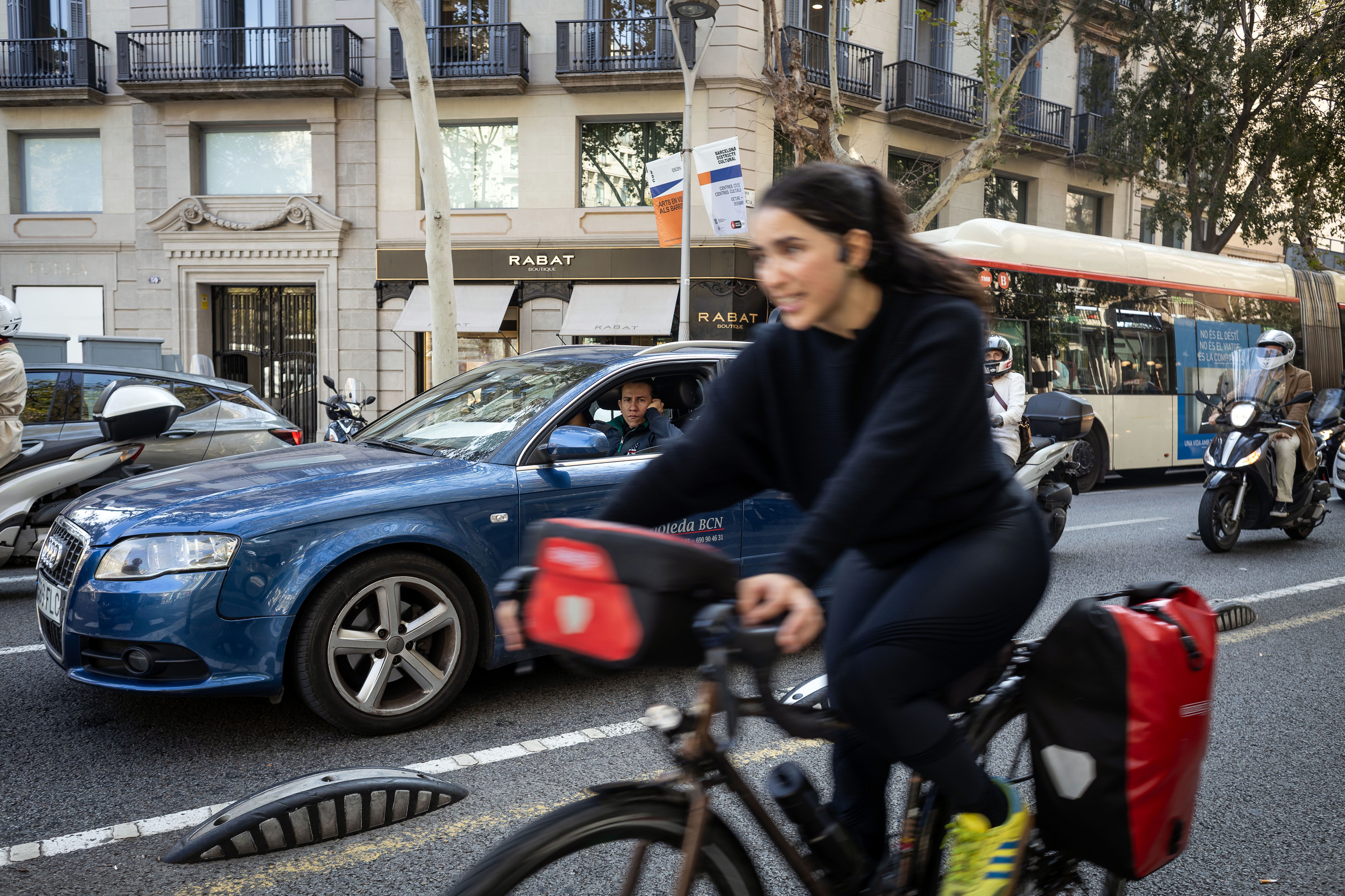 Un home mira una dona desplaçant-se en bici per Barcelona