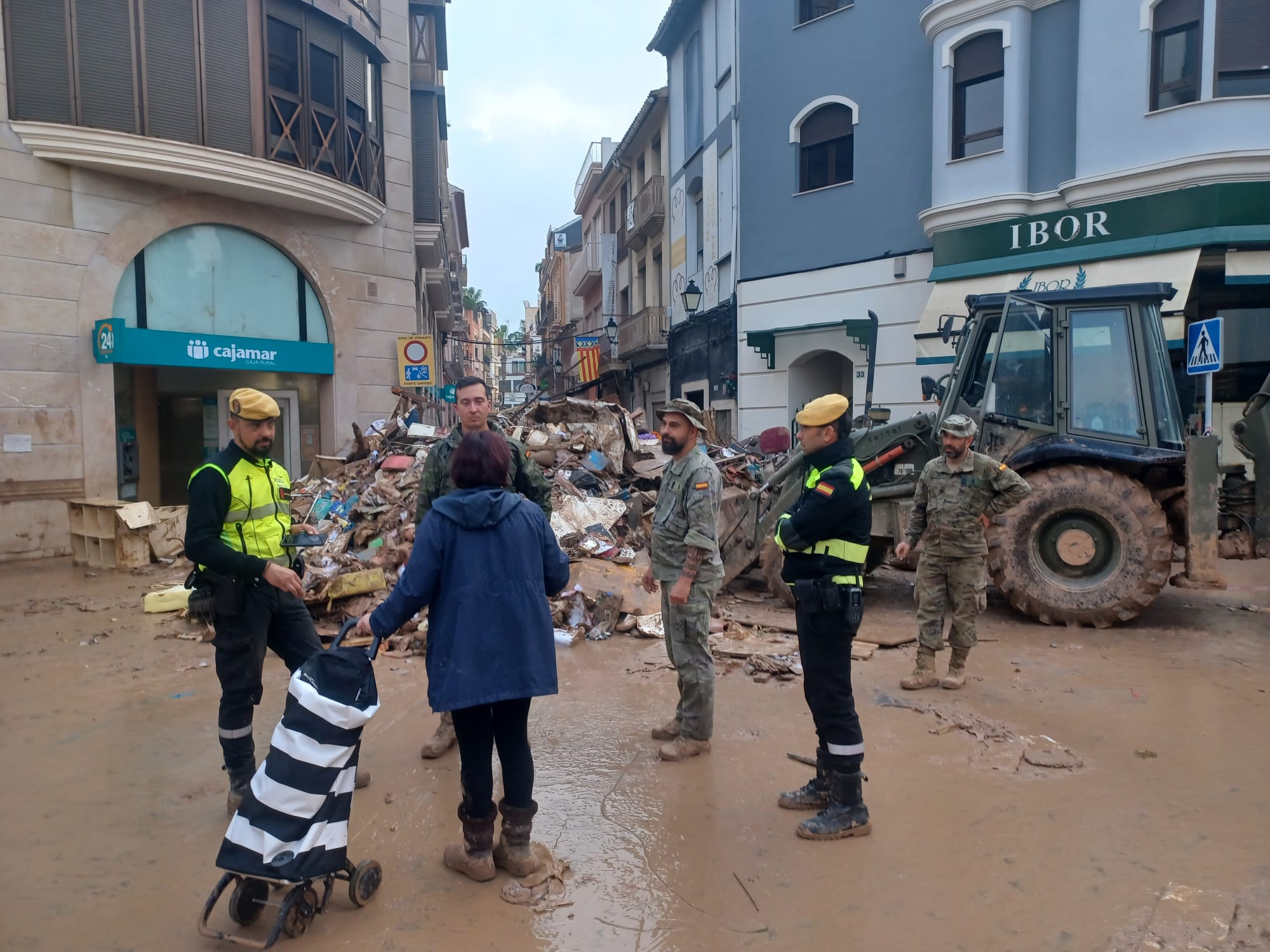 Soldats de l'exèrcit espanyol enviats a Algemesí per la DANA parlen amb una veïna