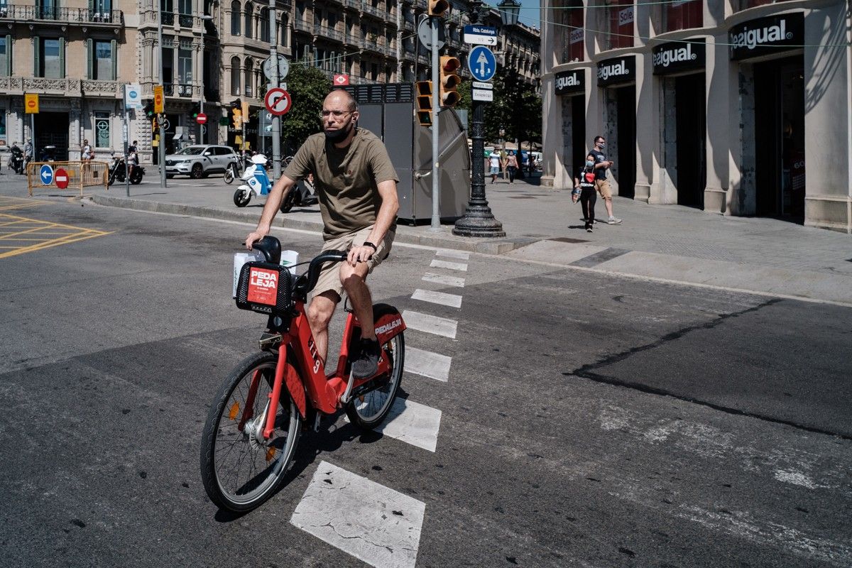 Un home amb bicicleta al centre de Barcelona, en una imatge d'arxiu