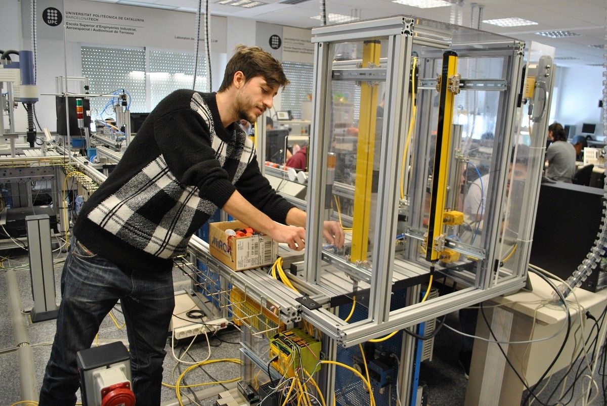 Estudiant de l'ESEIAAT fent pràctiques al laboratori  de robòtica i CIM  amb l'equip de seguretat Factory 4.0 de Pilz.