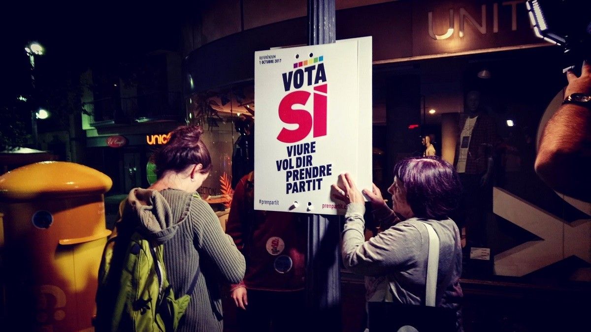 Enganxada de cartells de la CUP en la primera nit de campanya del referèndum