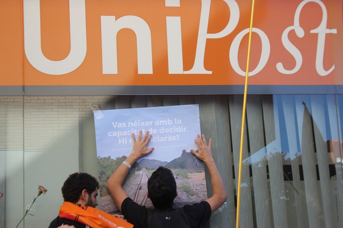 Uns manifestants pengen cartells del referèndum a la seu d'Unipost durant l'escorcoll de la Guàrdia Civil.