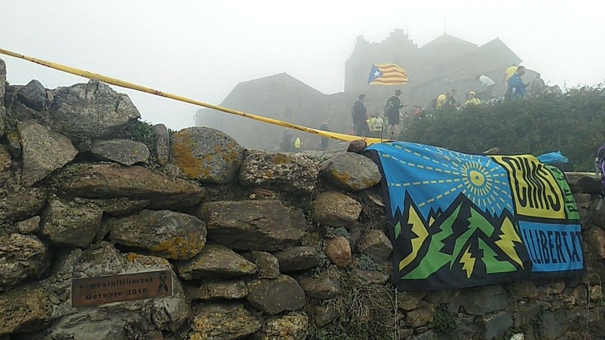 Desenes de persones amb banderes estelades al cim de la Roca Corbatera