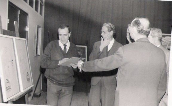 Concurs de pintura del XXV Aniversari d'AGUT SA. Josep Rigol i Fornaguera, que presidí el jurat; Joan Tarrés, un dels guardonats; i d'esquena, Joan Agut (4 de febrer de 1966) 