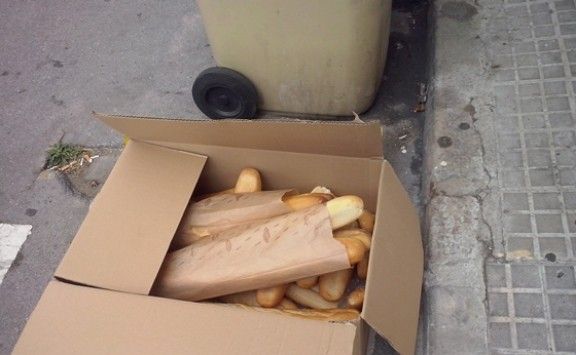 Caixa amb pa al costat d'un contenidor