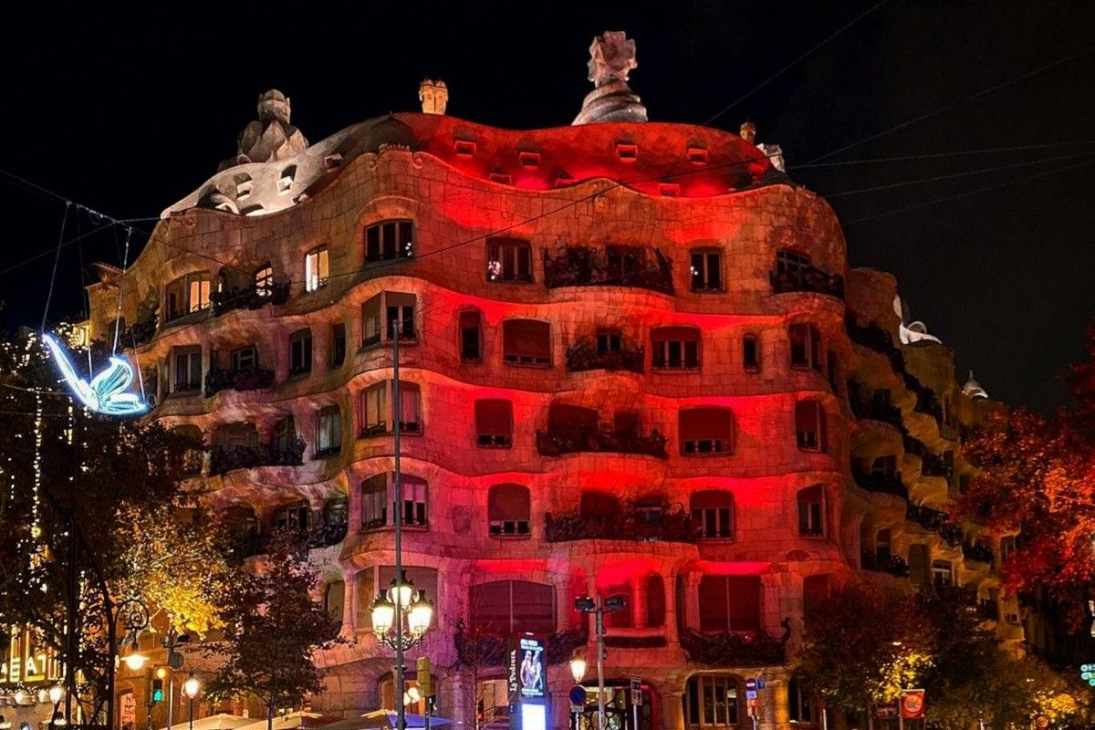 Pla general de la façana de la Pedrera il·luminada de color vermell per commemorar el Dia Mundial de la Sida