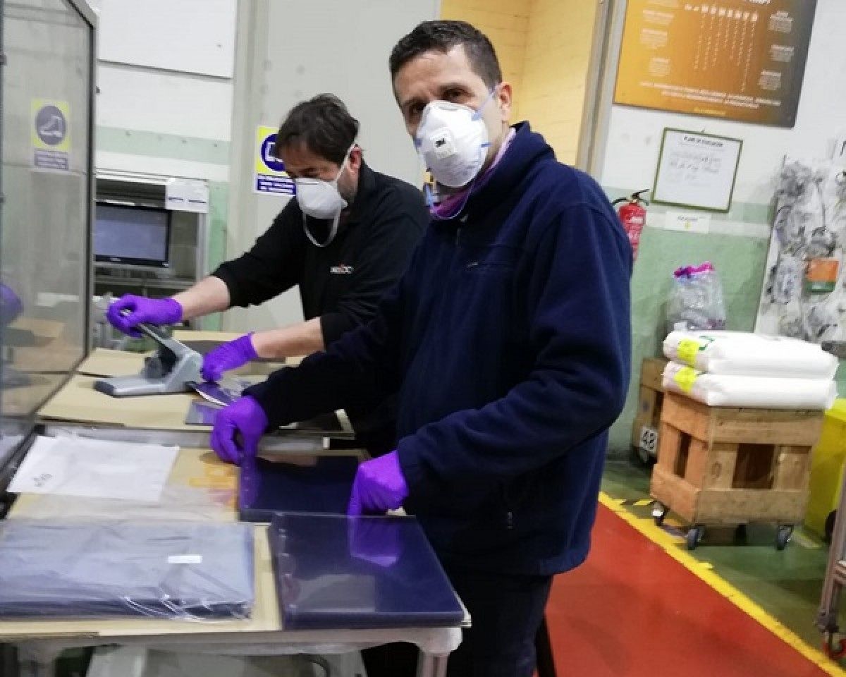 Treballadors de Nifco produïnt pantalles protectores.