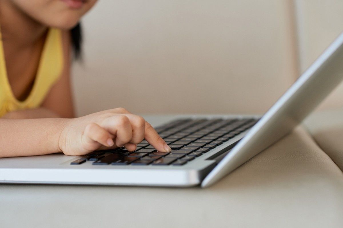Una nena utilitzant un ordinador portàtil.