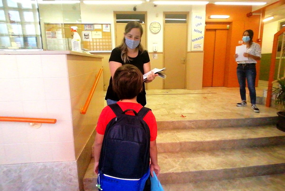 Una mestra pren la temperatura d'un alumnes a l'entrada d'una escola catalana.