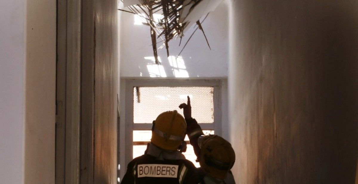Els Bombers revisen el sostre de canyís que ha caigut en una casa abandonada de Pintor Torres de Terrassa Foto: Cristóbal Castro
