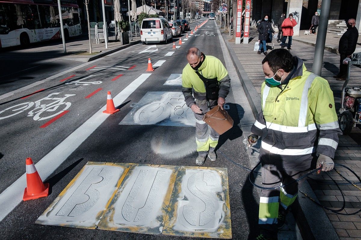 Operaris municipals pinten a la Rambla d'Ègara la senyalització de les normes de la  Ordenança de Mobilitat.