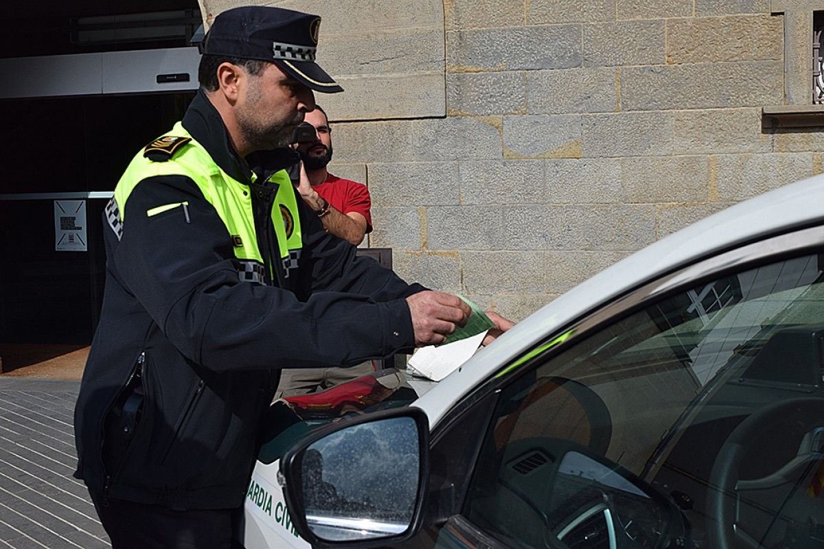 El cap de la Policia Municipal d'Olot, multant els vehicles de la Guàrdia Civil.